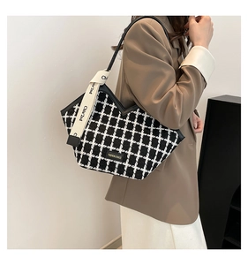 Detail of tweed checkered tote bag with V-shaped opening and stylish woven shoulder strap