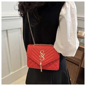 Detail of red quilted leather crossbody bag with gold SSS logo and chain tassel