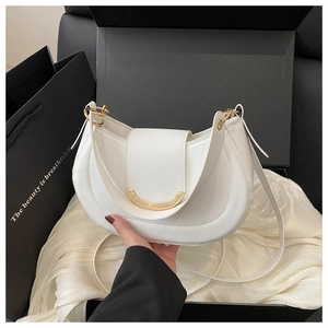 Detail of minimalist white saddle bag with golden crescent buckle on satin lining