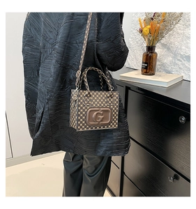 Detail of vintage pattern crossbody bag with brown leather patch and G logo