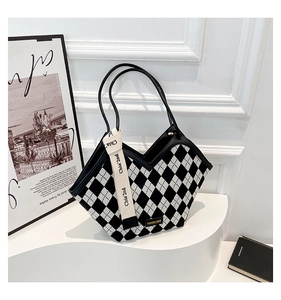 Detail of checkered tote bag with V-shaped cut and Chia'2nd ribbon on a white pedestal