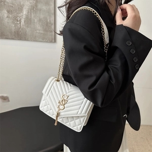 Elegant white quilted crossbody bag with gold chain strap and metal tassel detail