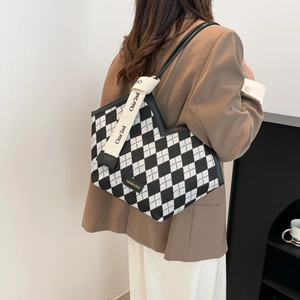 Chic black and white checkered tote bag with V-shaped cut and woven strap on shoulder