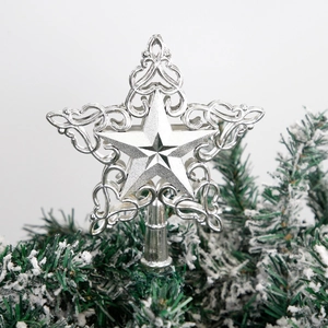 Silver hollow star Christmas tree topper with elegant scrollwork on a snowy pine tree