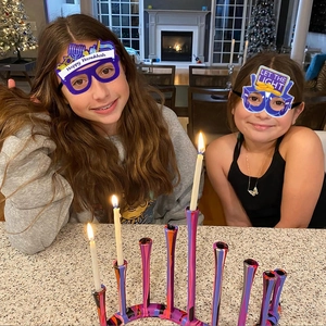 Gros plan de lunettes de fête Hanoucca avec bougies et un chandelier de ménorah coloré