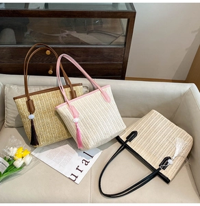 Three straw woven tote bags in brown pink and black with leather straps and tassel details
