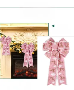 Close-up of pink Christmas ribbon bow with gold reindeer and white tree patterns