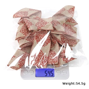 Close-up of red floral linen Christmas bow showing 54.5g weight on a scale
