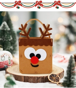 Close-up of a brown felt Christmas reindeer gift bag on a rustic wood slice setting