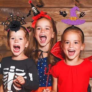 Three kids wearing various Halloween witch hats headbands with spooky festive decorations