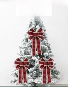 Detail of red and black plaid Christmas bows with burlap edges on a snowy tree
