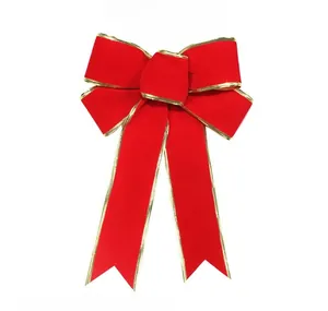Close-up of a large red velvet Christmas bow featuring golden edges and swallowtail cut