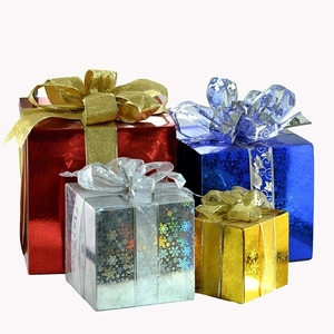 Close-up of four glittery Christmas gift boxes with snowflake patterns and bows
