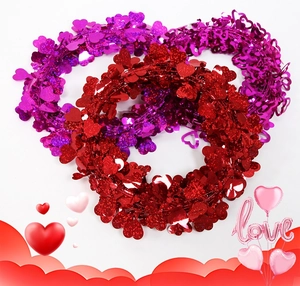 Dettaglio di ghirlande a forma di cuore rosse e viola con finitura glitterata