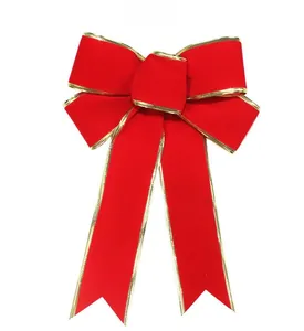 Detail of red velvet Christmas bow with gold braided edges for holiday tree decoration