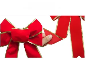 Detailed view of red velvet Christmas bow with gold metallic edge trim and soft texture
