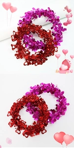 Dettaglio di ghirlande di glitter a forma di cuore rosso e viola per decorazioni festive