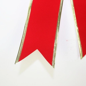 Large red velvet Christmas bow with gold trim for festive tree and holiday decoration