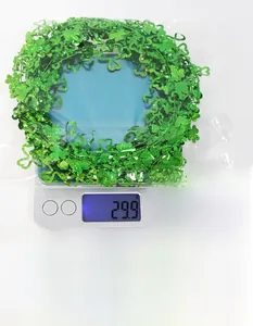 Green shamrock tinsel garland for St. Patrick's Day being weighed on a scale showing 29.9g