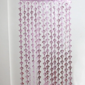 Détail du rideau à franges en aluminium or rose avec motifs en forme de diamant
