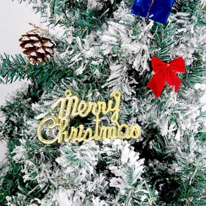 Golden glittery Merry Christmas sign with red bow on a snowy pine tree branch