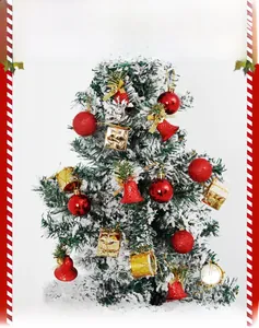Close-up of red and gold Christmas ornaments including bells and baubles on a snowy pine tree