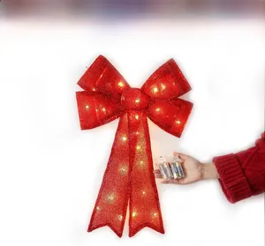 Detail of red lighted Christmas bow with mesh fabric texture and warm LED bulbs inside