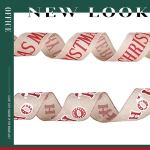Dettaglio di nastri natalizi in lino con stampe rosse Merry Christmas e scritte Ho Ho Ho