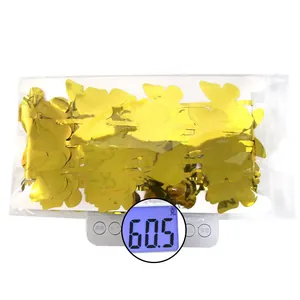 Close-up of golden butterfly fringe curtain showing weight of 60.5g on a scale