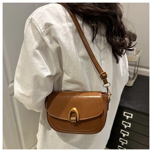 Brown vintage saddle bag with oily texture leather and gold metal U-lock on a model