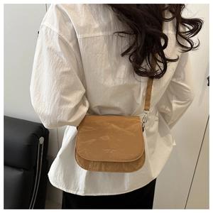 Détail d'un sac bandoulière marron clair avec texture papier unique et imprimé tendance