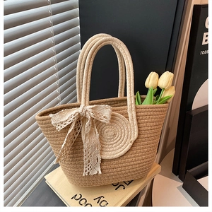 Détail du sac à main en paille avec nœud en dentelle et poignées rondes en décor intérieur