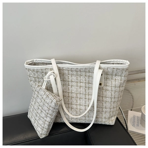 Detail of tweed tote bag set with white leather trim and luxury woven texture