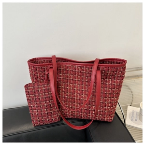 Detail of red tweed tote bag set featuring gold metallic weave and leather handles
