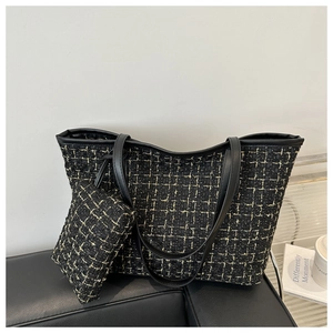 Detail of black tweed tote bag with gold thread weaving and small matching pouch