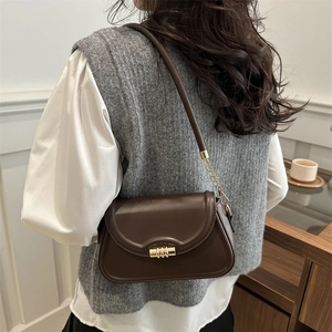 Stylish brown leather shoulder bag for women with golden buckle in minimalist design