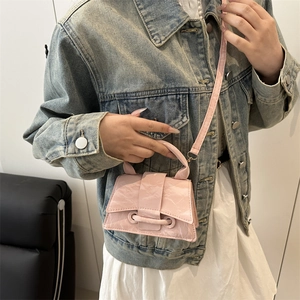 Pink crinkled leather mini crossbody bag styled with a blue denim jacket and dress