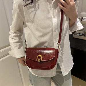 Vintage burgundy saddle bag with glossy finish and gold U-shaped hardware for women