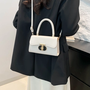 White leather crossbody flap bag with gold T-lock shown on a black blazer