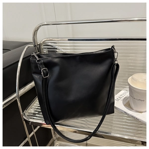 Gros plan d'un cabas noir minimaliste en cuir PU sur une étagère en métal moderne