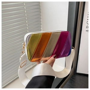 Detailed close-up of rainbow metallic stripe panel and white leather texture on camera bag