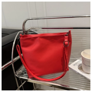Détail d'un sac cabas en cuir PU rouge vif avec des garnitures en métal noir fusil