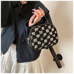Gros plan du mini sac à main en tweed à damier noir et blanc avec bords effilochés