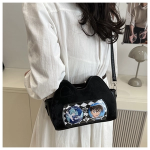 Detail of black cat-ear ita bag with transparent PVC window displaying anime badges