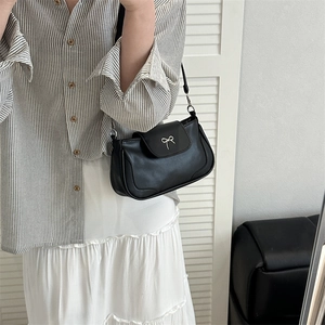 Sac sous le bras minimaliste en similicuir noir avec boucle nœud argenté sur modèle