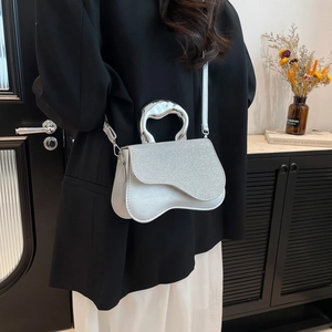 Silver glitter crossbody bag with unique irregular metal handle and leather shoulder strap