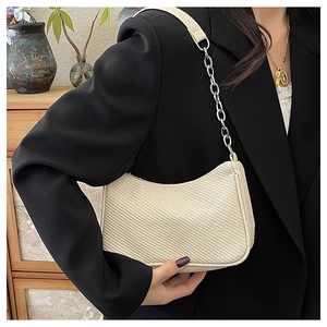 Detailed macro view of beige woven texture and silver chain on half-moon hobo bag