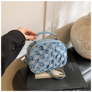 Détail du sac à bandoulière bleu clair avec patchwork en denim et poignée supérieure