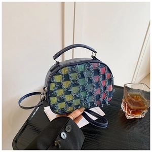 Détails de la texture en tweed coloré et des franges sur un sac bandoulière de luxe