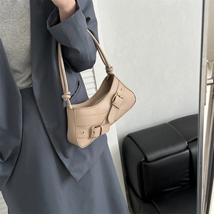 Beige faux leather underarm bag with metal buckle straps shown on a grey blazer outfit